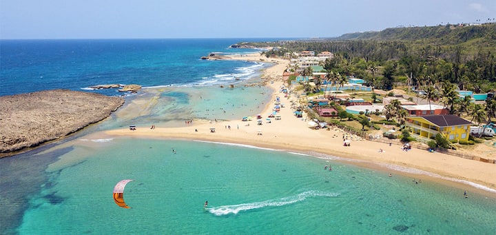Aerial view of a golden sand beach and turquoise water on Puerto Rico's northwest coast