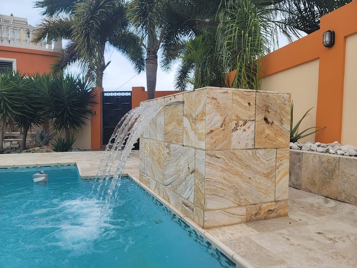Stone waterfall spilling into the pool at Oasis Escape House