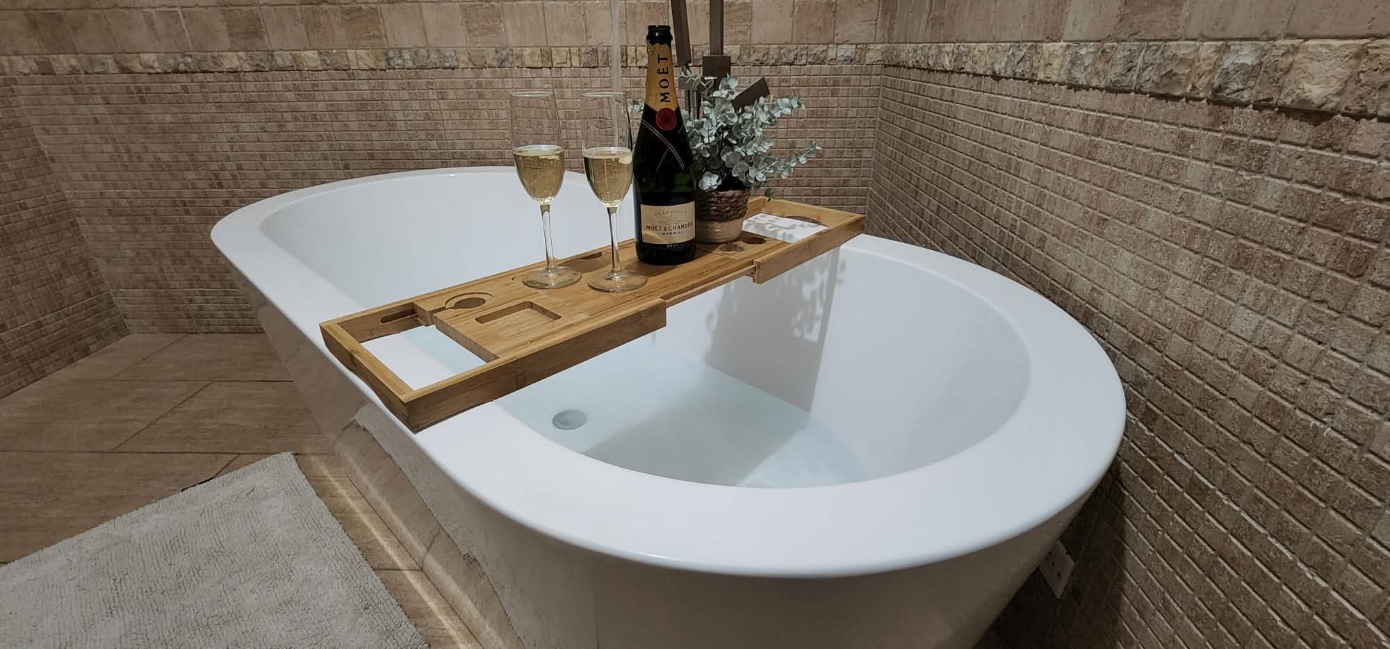 Freestanding tub with a wooden tray and glasses
