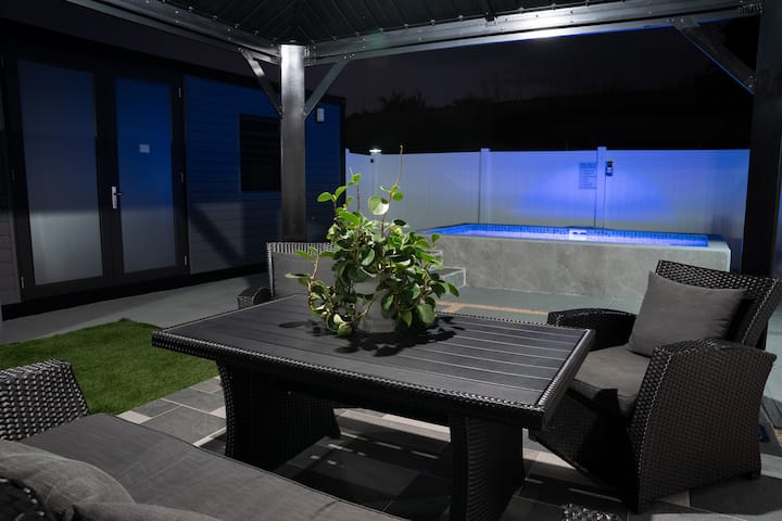 Westside Escape at night, pool lit blue beside the gazebo