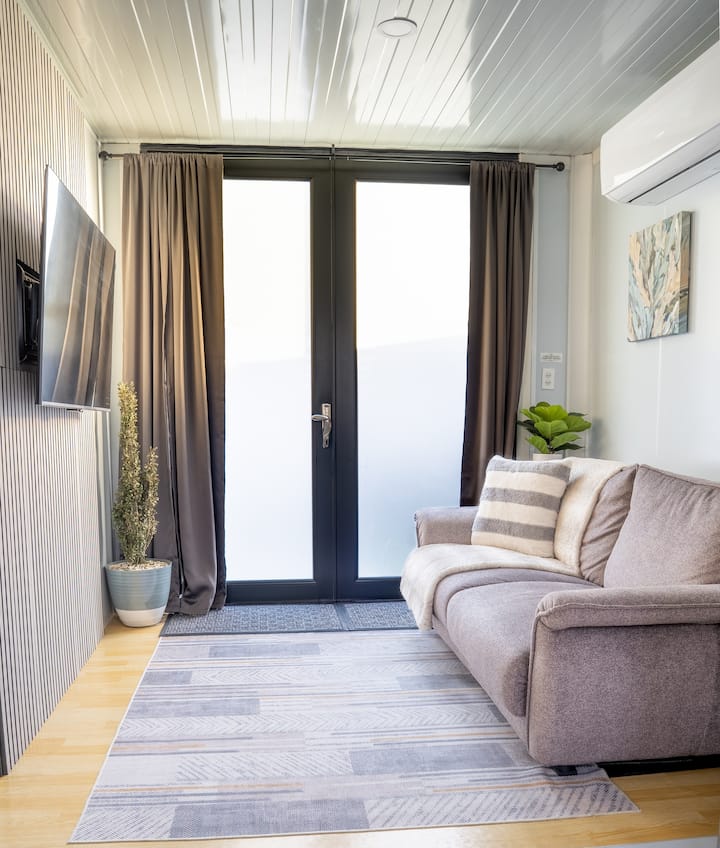 Living room with sofa, TV and French doors at Westside Escape