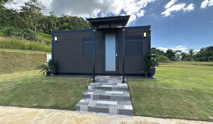 Westside Escape's facade on a green hillside in Añasco